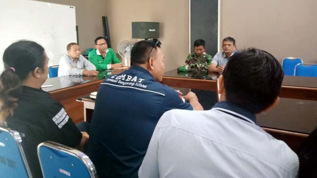 MASIH DIDUGA : Kades Genteng Kulon Supandi (Kaos Hijau) didampingi Pendamping Desa Iqbal, saat menjelaskan biaya PTSL kepada LSM Cambat dan membantah adanya pungli. (tut)