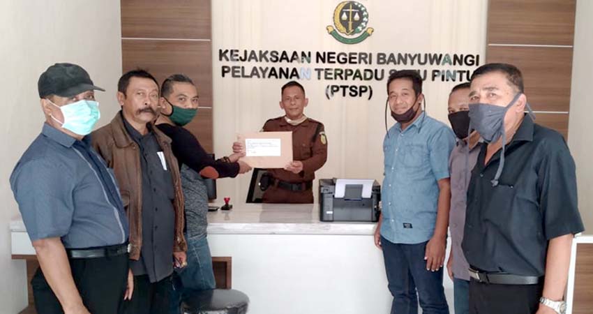 Puluhan Anggota Masyarakat Peduli Aset Desa Kebaman (MPADK) saat menyerahkan laporan dugaan penjualan aset desa di Kejari Banyuwangi, Senin (22/6/2020) siang. (tut)